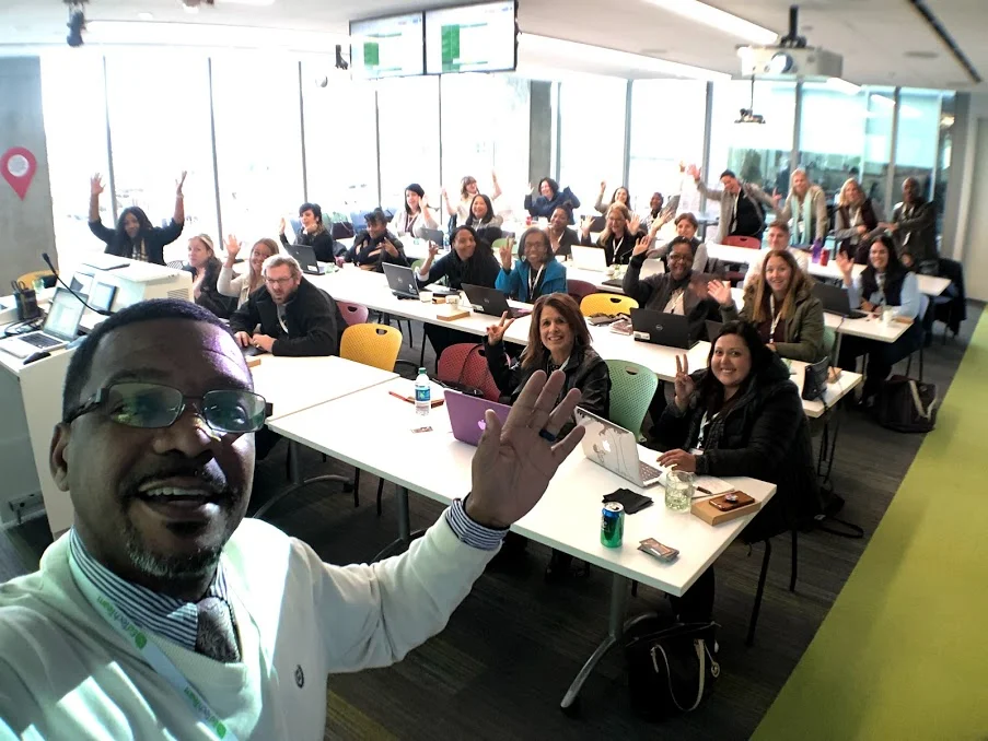 Wiley and a room of educators waving at the camera
